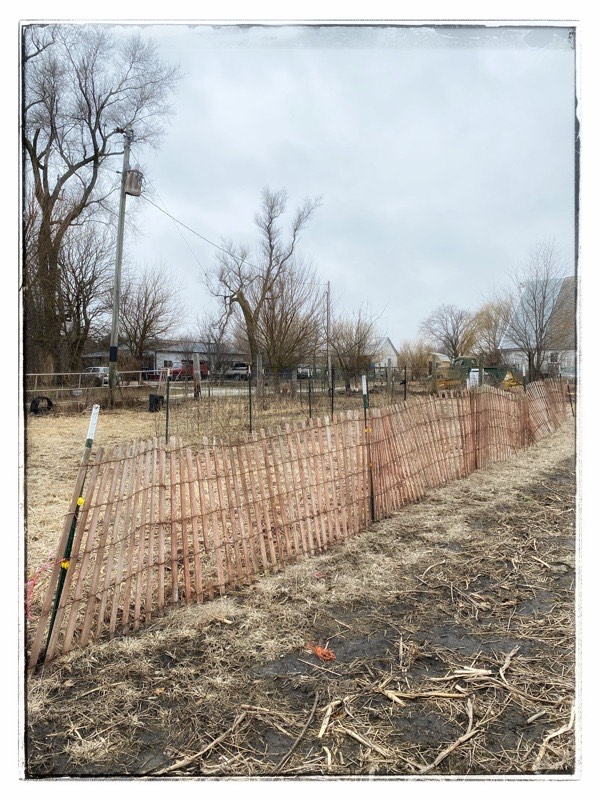 old wooden snow fence in snow free field