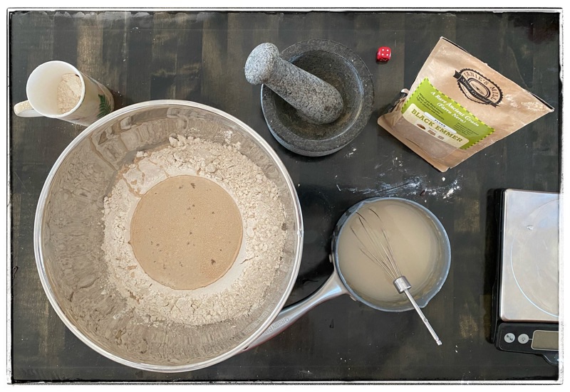 bowls of flour and water and yeast and salt  and roux all ready to make bread. 
