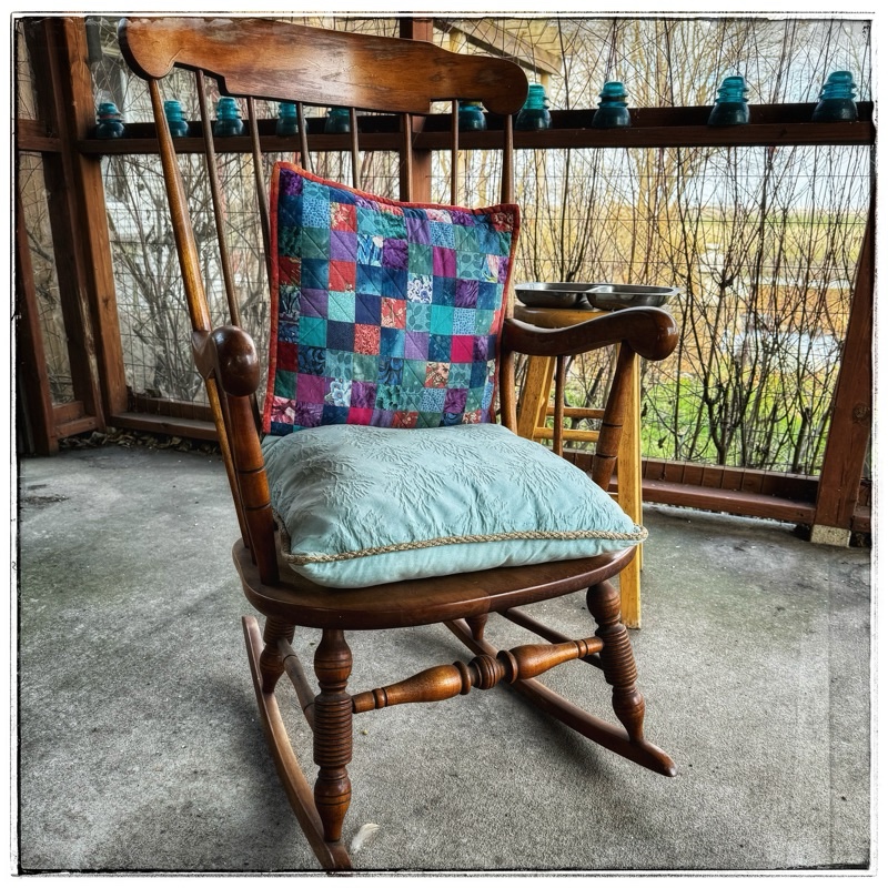 Rocking chair wooden rocking chair with colorful cushions on porch
