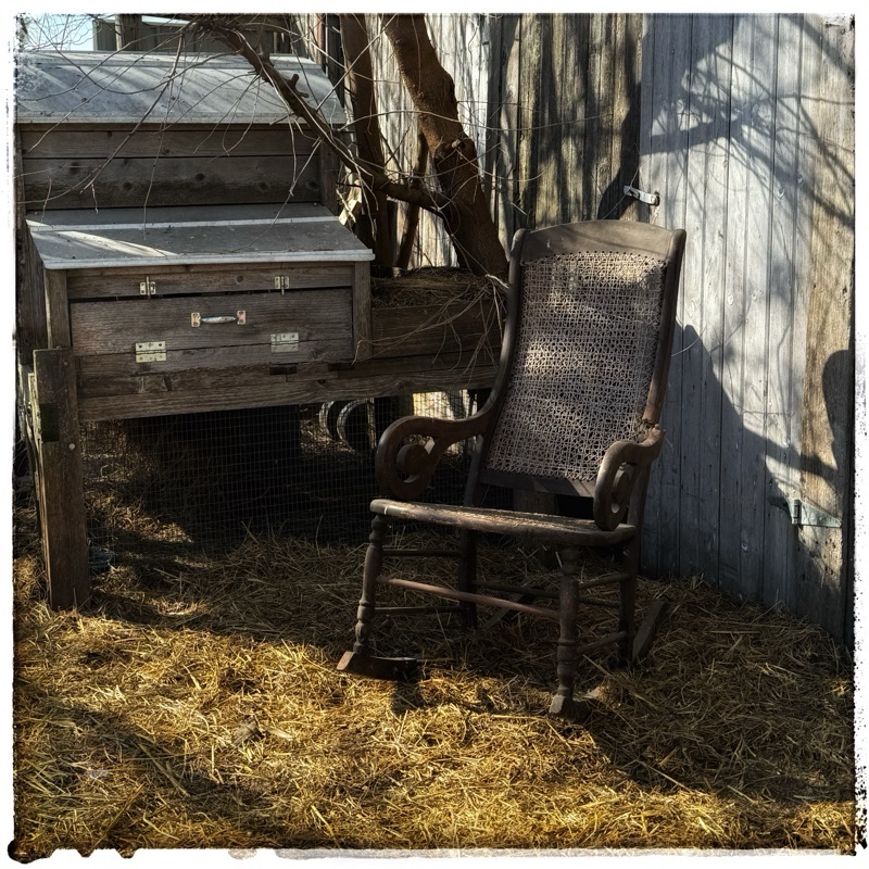 Rocking chair in front of barn wall